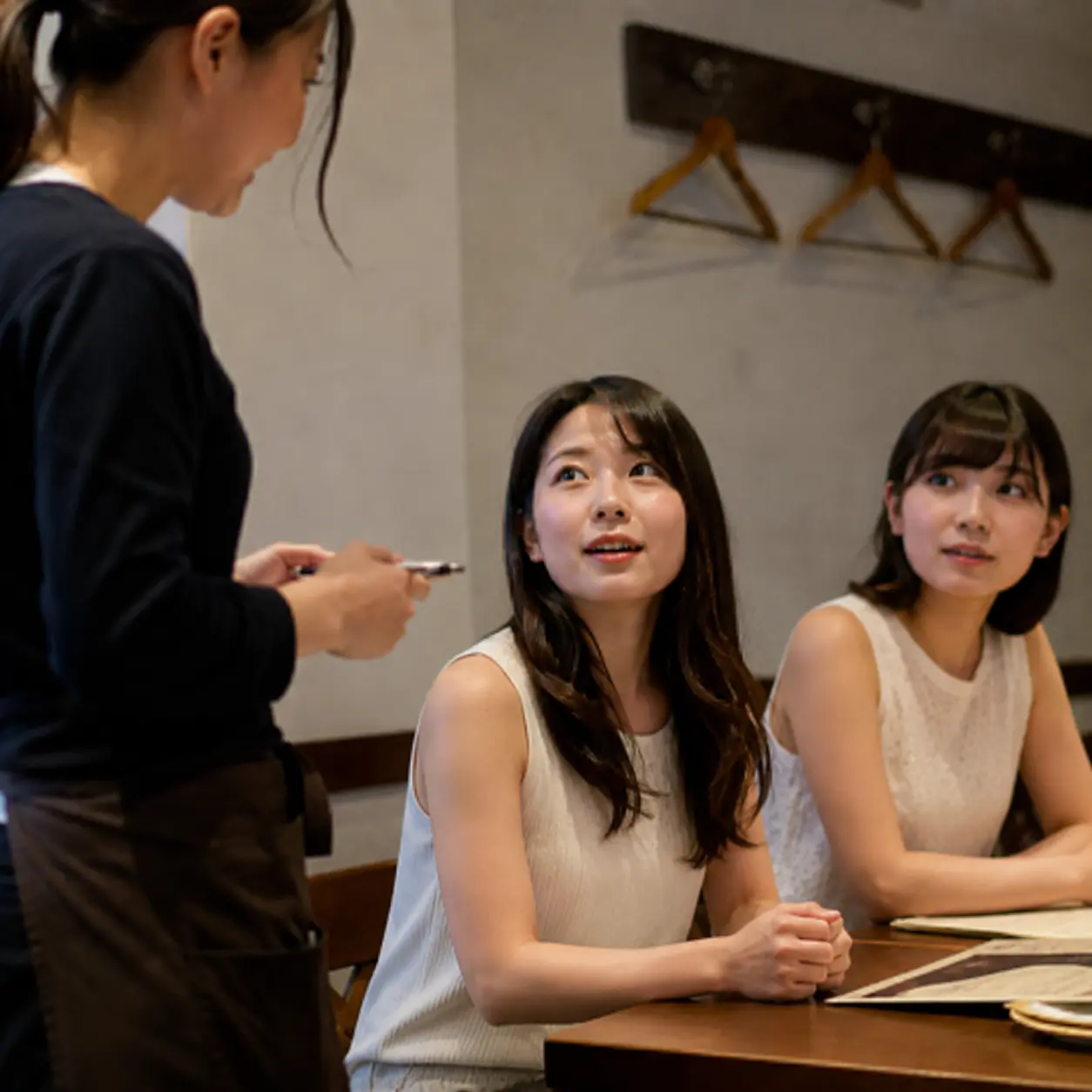 席に着いたばかりのお客様に注文確認をするスタッフ