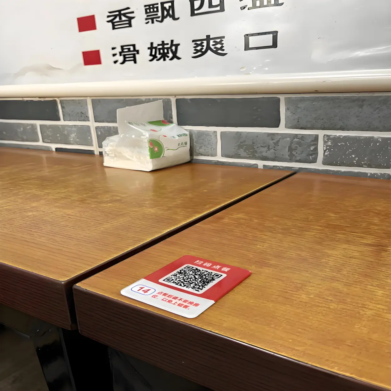 中小飲食店のテーブルに置かれたQRメニューをスマホで読み取る様子